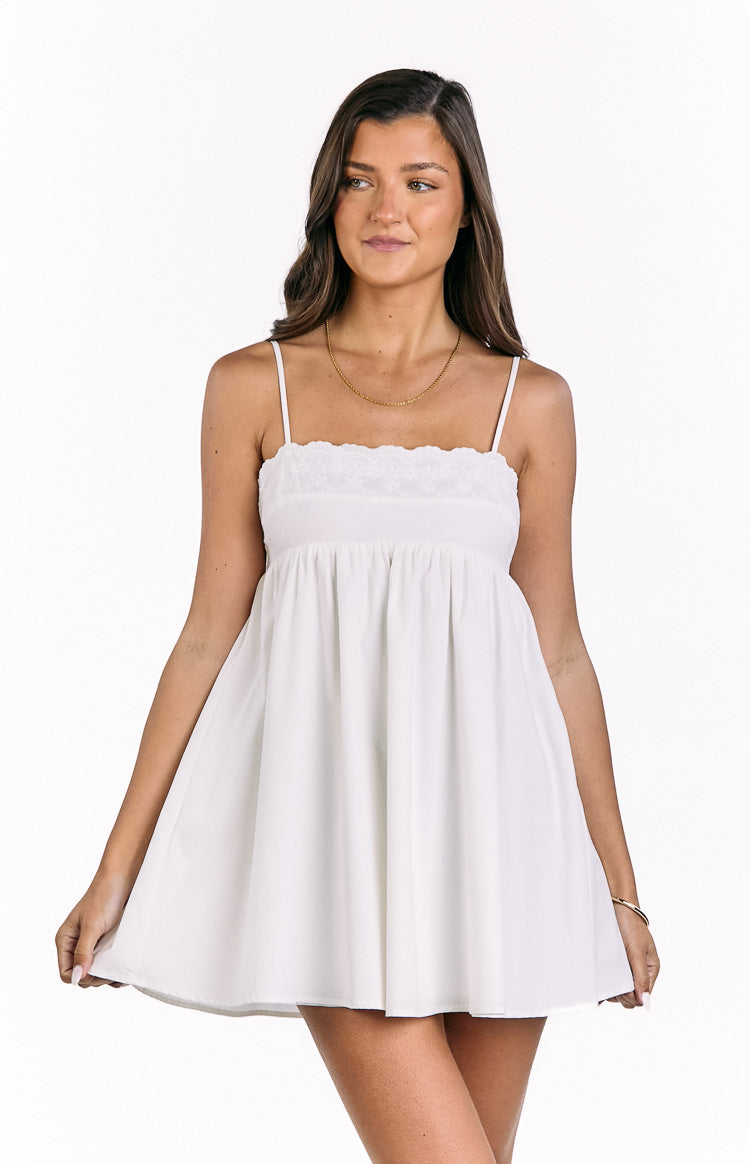 White babydoll mini dress with delicate eyelet embroidery along the square neckline and thin spaghetti straps
