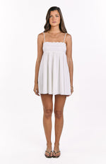 White babydoll mini dress with delicate eyelet embroidery on the bust and thin spaghetti straps
