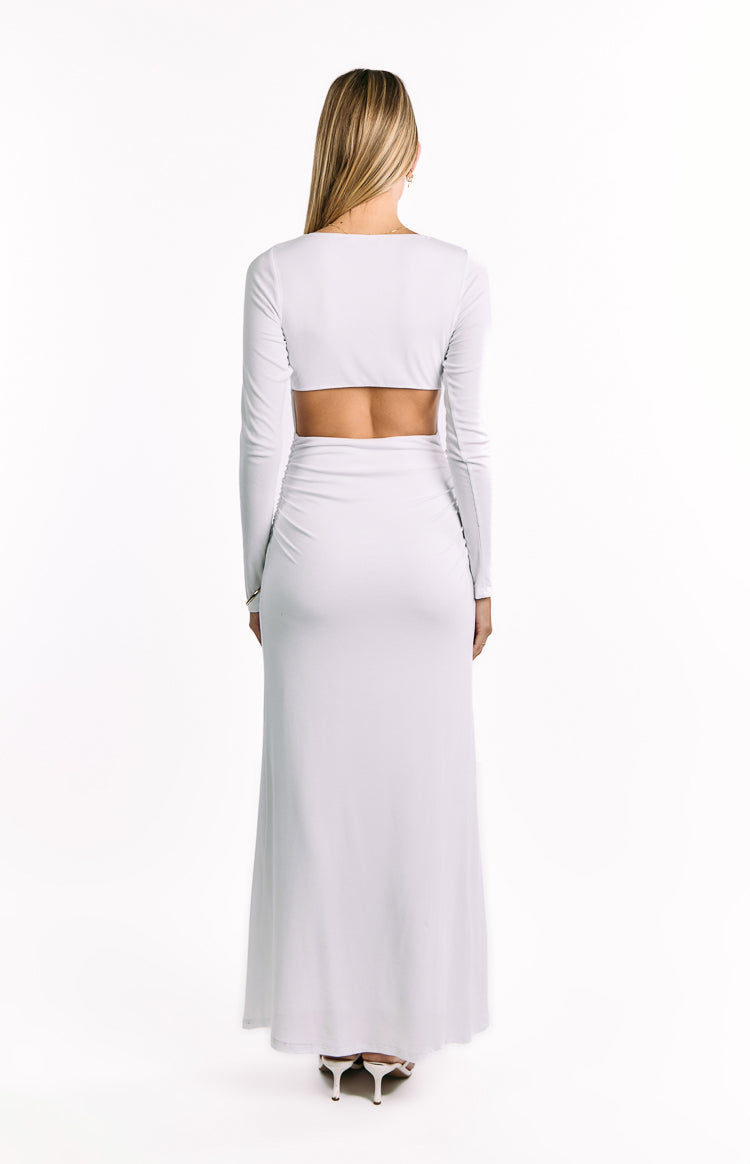 Rear view of a white long sleeve maxi dress with a lower back cutout and ruched skirt detail
