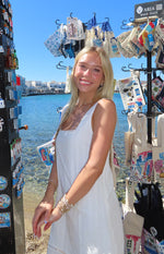 Close-up of the square neckline with delicate lace trim on a white sleeveless mini dress