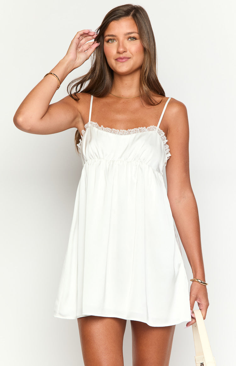 White mini dress featuring delicate lace trim along the straight-across neckline and gathered bodice