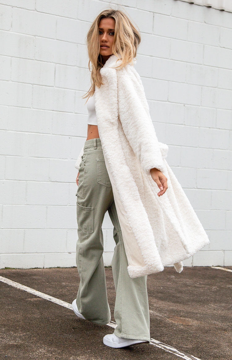 Rear view of a white midi length teddy coat with long sleeves and a belted waist