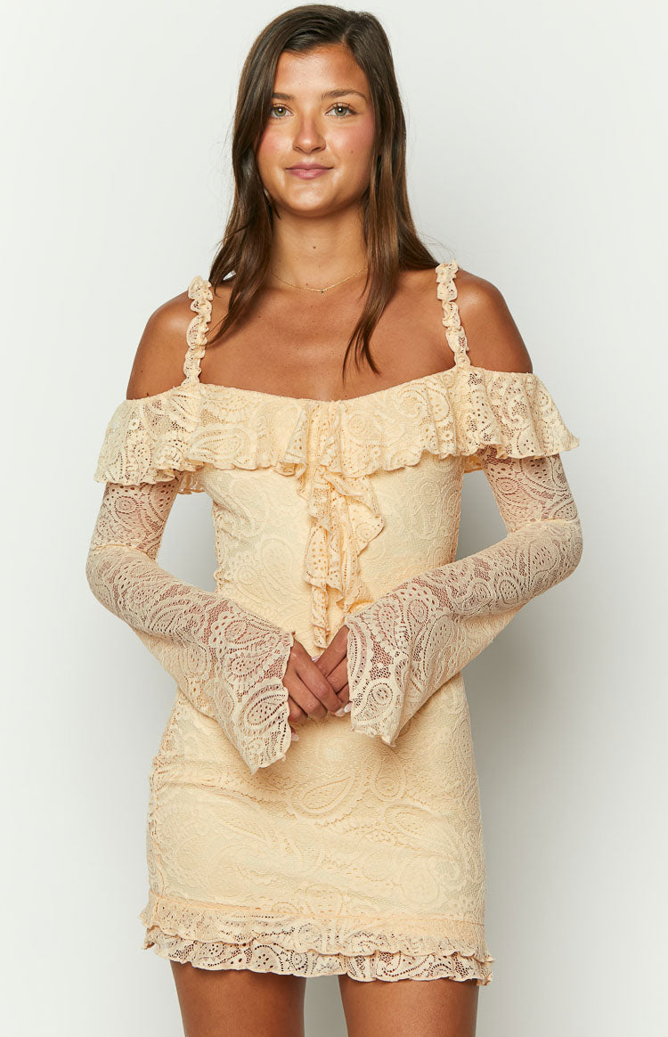 Front view of a cream paisley lace mini dress with an off-shoulder ruffled neckline, long bell sleeves, and ruffled bodice detail