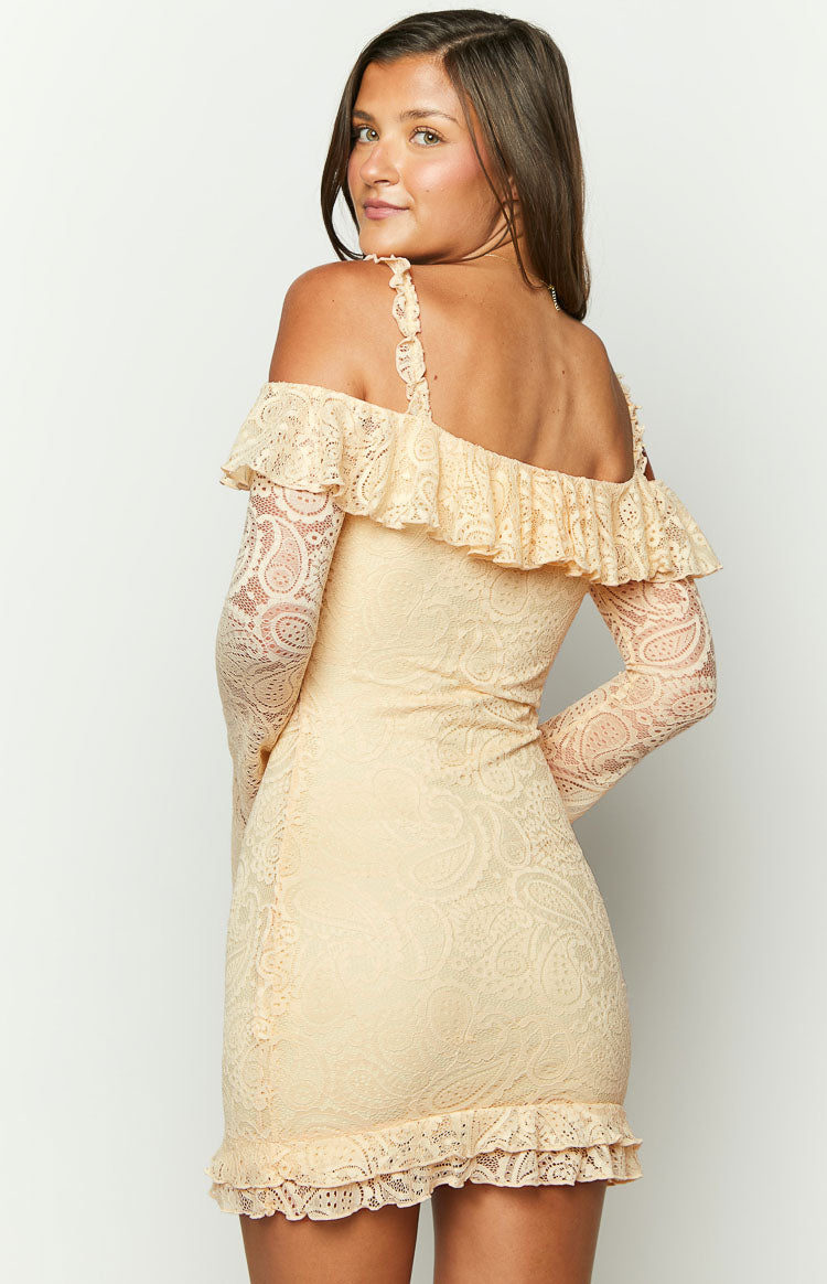 Side-back view of a cream paisley lace mini dress with off-shoulder ruffle, long sleeves, and a ruffled hem