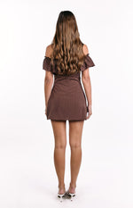 Rear view of a brown polka dot off-shoulder mini dress with ruffled sleeves and a fitted waist