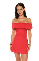 Our model wearing a red off-the-shoulder mini-dress with a small white polka dot pattern featuring a flounce ruffle along the elasticized neckline and a fitted bodice.