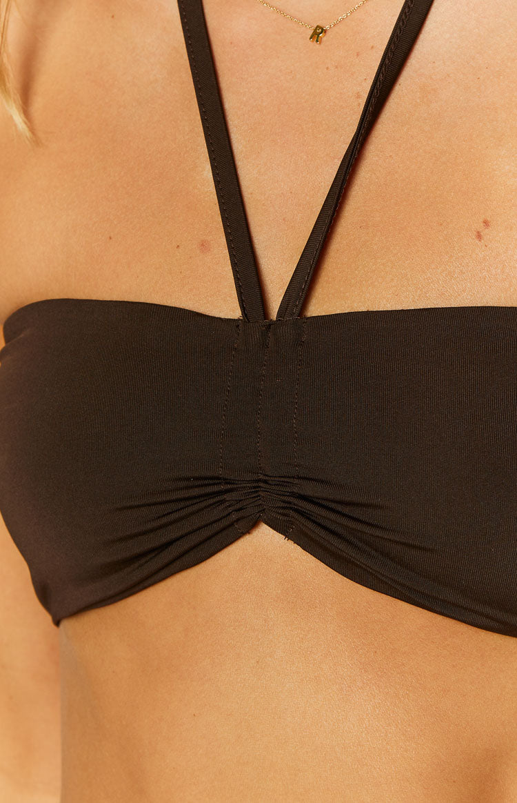 Side view of a chocolate halter crop top with a bandeau style back and thin neck strap
