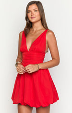 Close-up of the deep V-neckline and ruched waist detail on a red sleeveless mini dress