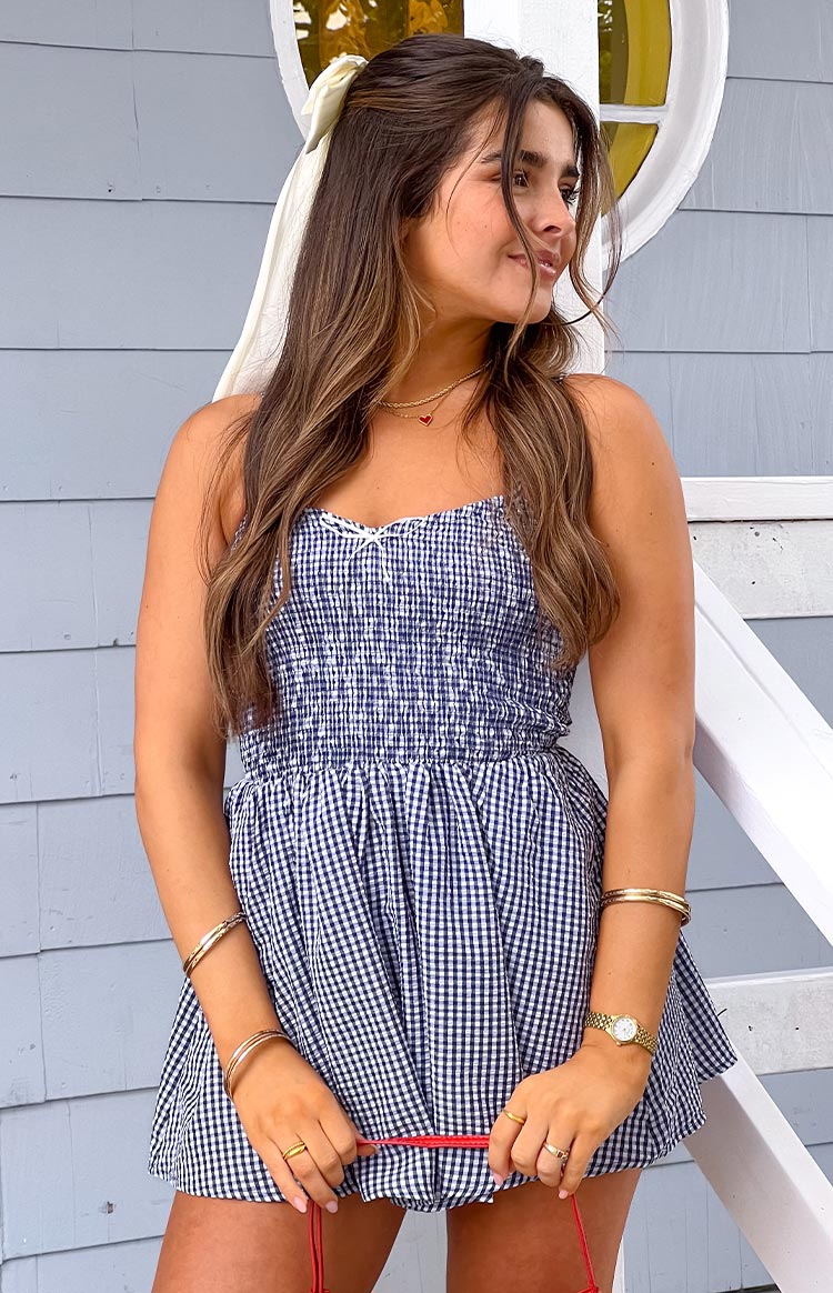 Beginning Boutique Heidi Navy Gingham Playsuit navy gingham smocked playsuit with sweetheart neckline, thin straps, bow, and relaxed shorts