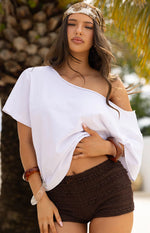 Close-up of chocolate micro shorts with a textured, ruffled surface and a small bow detail at the front