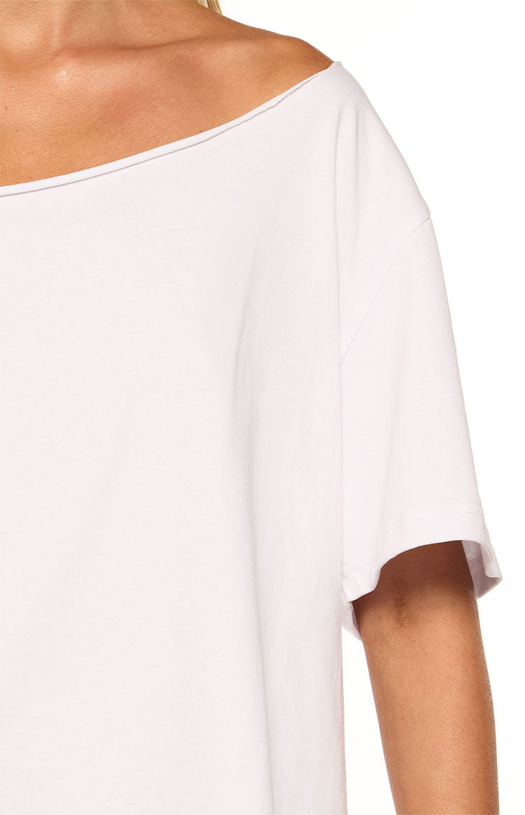 Close-up of the raw edge off-shoulder neckline and short sleeve of a white boxy tee