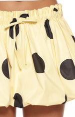 Close-up of the yellow polka dot mini skirt showing the elasticated ruched waistband and drawstring