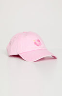 Blonde model wearing a washed pink baseball cap with an embroidered floral graphic
