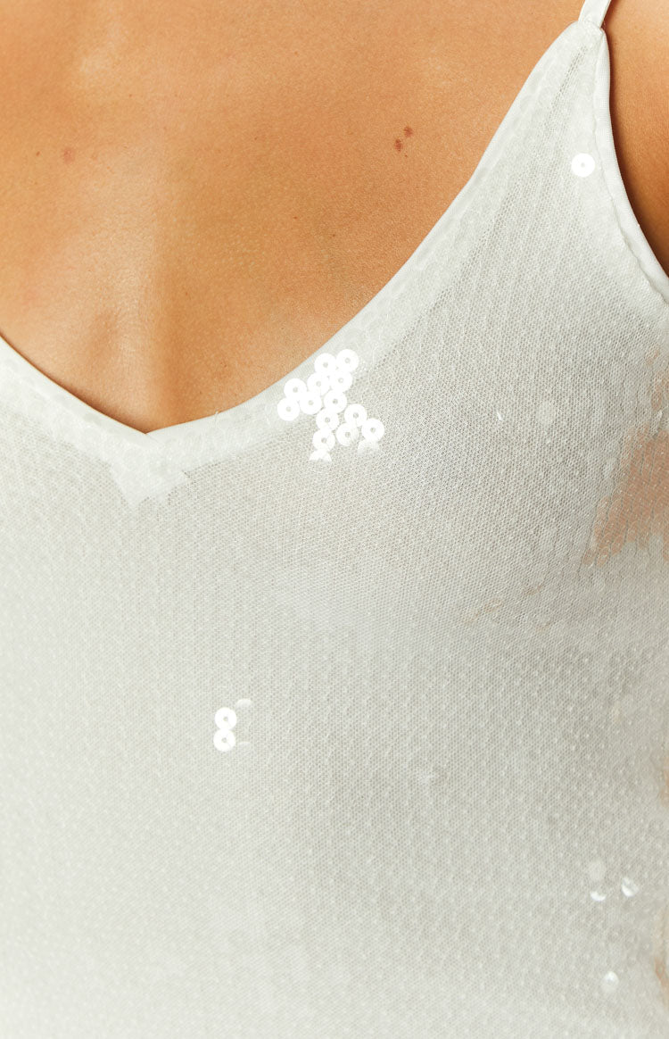 Close-up of the cream sequin mini dress showing the V-neckline and scattered sequins on sheer fabric