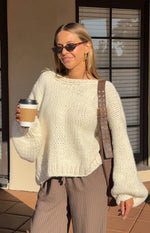 Rear view of a cream chunky knit cardigan with a deep V-back and tie-up detail forming a bow