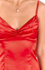 Close-up of the red satin mini dress showing the ruched sweetheart neckline and thin spaghetti straps