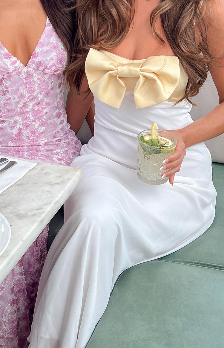 Side-rear view of a yellow strapless bodice with a structured back and a white flowing maxi skirt