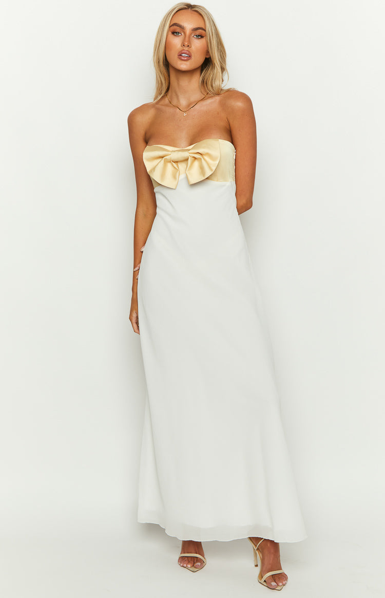 Front view of a white strapless maxi dress with a large yellow satin bow detail on the bust