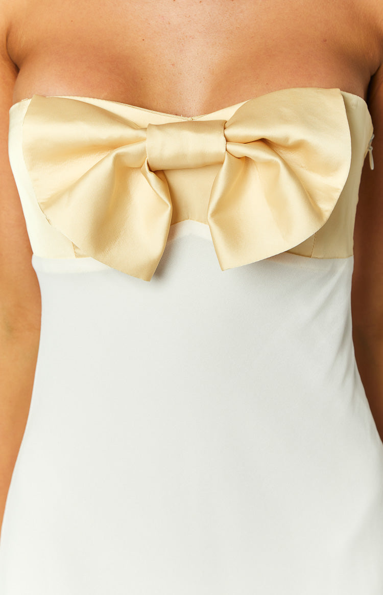 White maxi dress with a large yellow satin bow on the bust and thin spaghetti straps