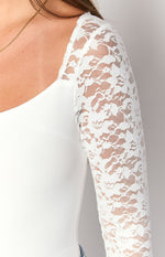 Close-up of the white lace long sleeve and the plain white bodice with a square neckline