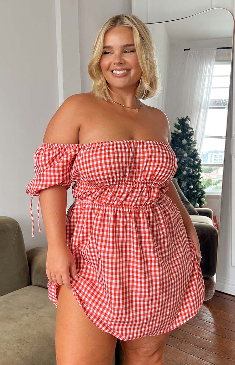 Rear view of a red gingham mini dress with an off-shoulder neckline, shirred waist, and puff sleeves with ties