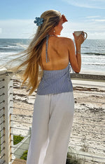 Rear view of a blue and white striped halter neck top with an open back and side ties