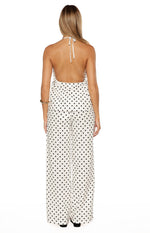 Rear view of a flowy white polka dot halter top with a low scoop back and neck ties