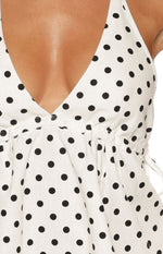 Close-up of the white polka dot top showing the V-neckline, gathered bust, and side tie detail