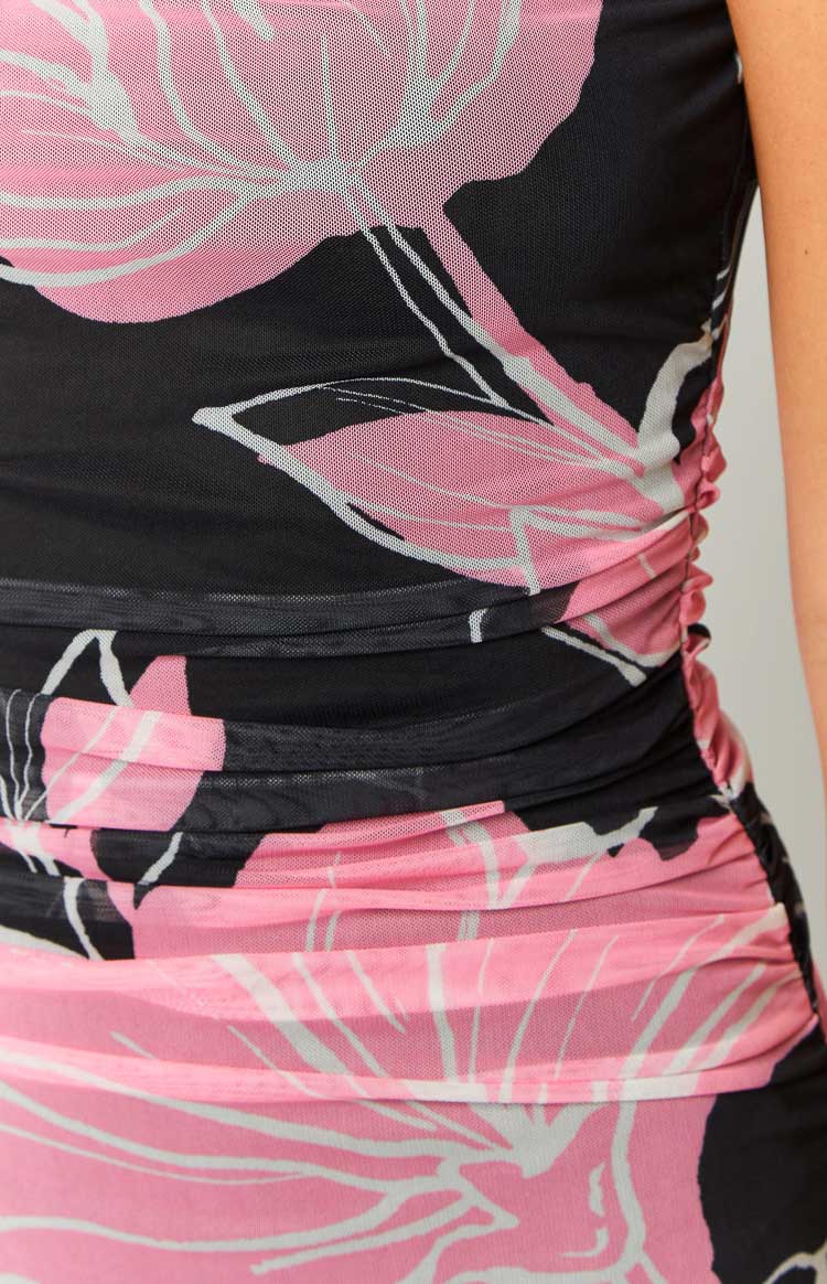 Close-up of the ruched side seam detail on a black and pink floral print maxi dress