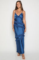 brunette model wearing a navy blue satin formal gown with chiffon ruffle details