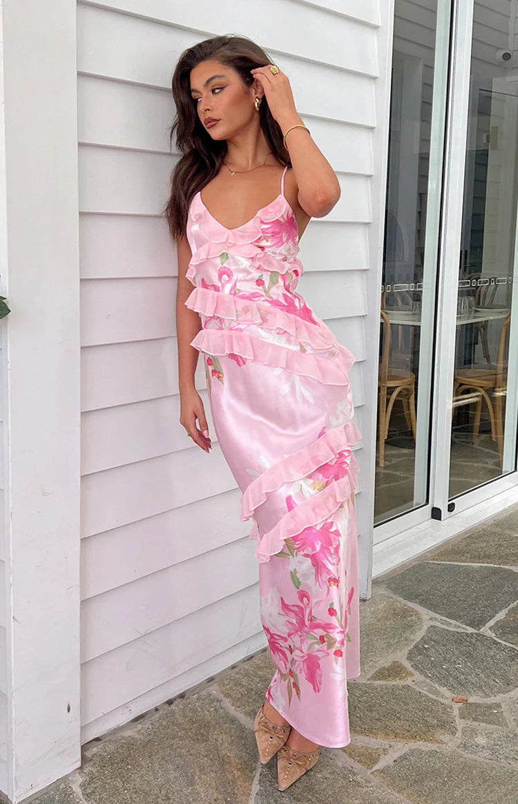 Side view of a pink floral print maxi dress showing side cutouts, tiered ruffles, and tie-back detail