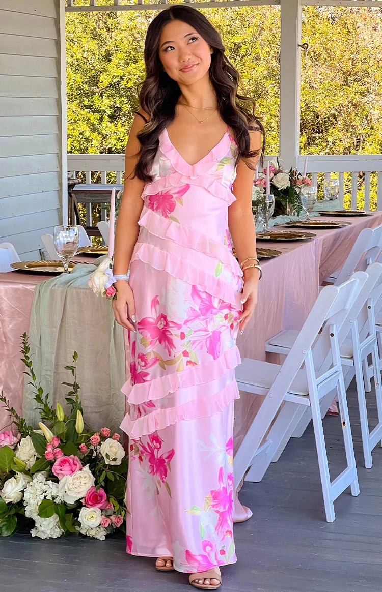 Side view of a pink floral print maxi dress with tiered ruffles and criss-cross back straps