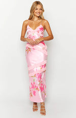 Front view of a pink satin floral print maxi dress with a V-neck, spaghetti straps, and tiered ruffles