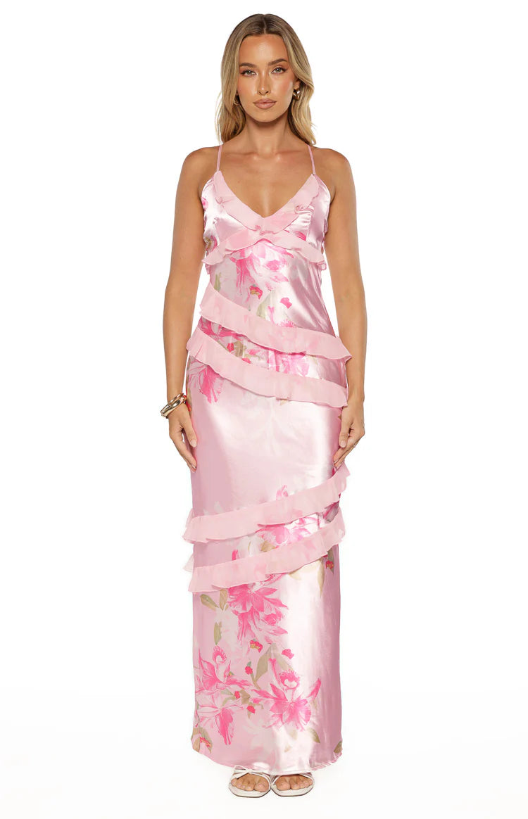 Side view of a pink floral print satin maxi dress with tiered ruffles and spaghetti straps
