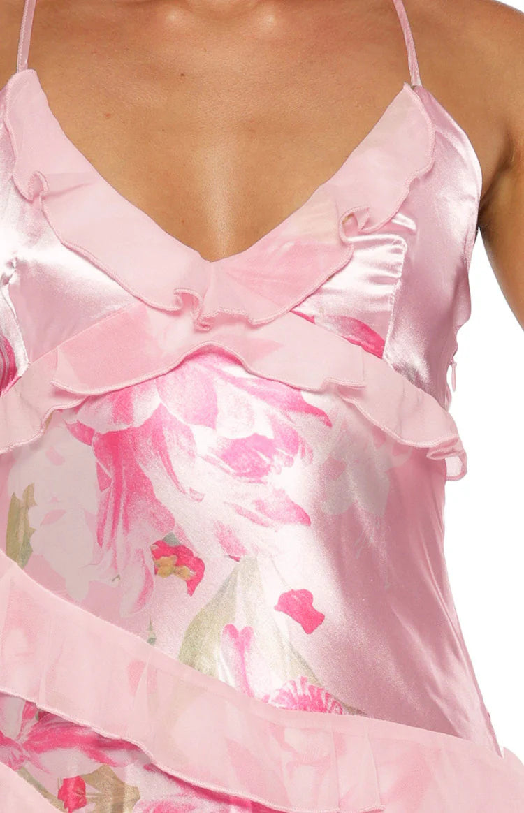 Rear view in mirror showing criss-cross tie-back straps on a pink floral ruffle maxi dress