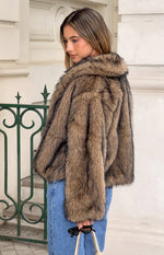 Side view of a chocolate faux fur jacket with a broad collar and textured brown and dark striped pattern