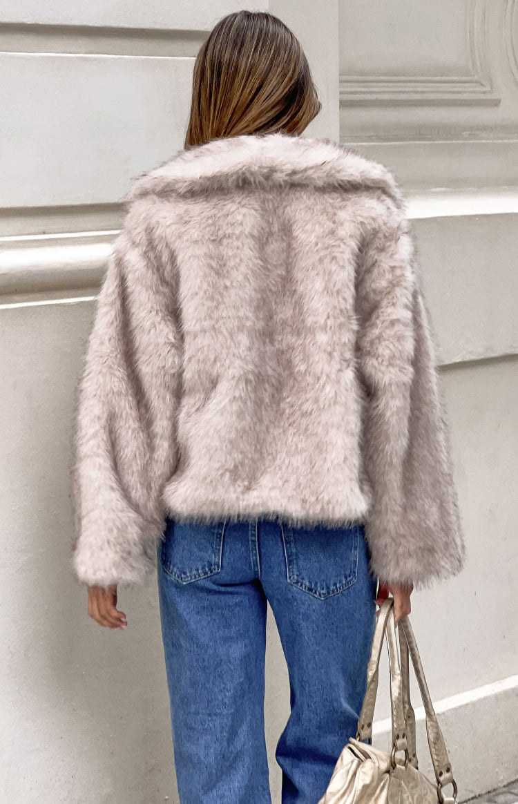 Rear view of a sand faux fur jacket with a wide collar and long voluminous sleeves