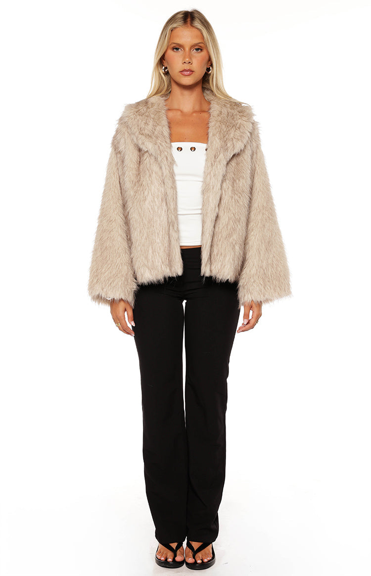 Front view of a sand faux fur jacket with wide lapels and long relaxed sleeves