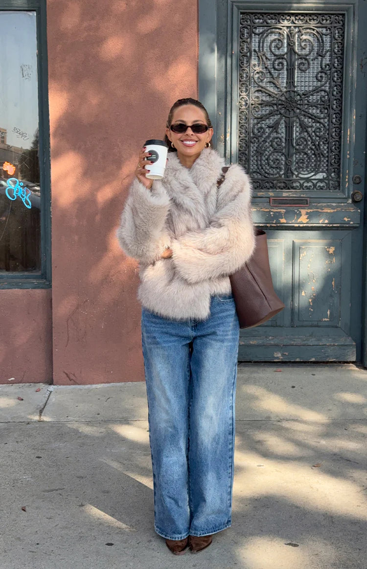 Side view of a sand faux fur jacket with a shaggy texture and voluminous sleeves