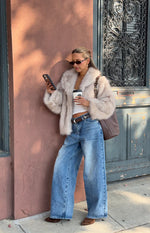 Sand faux fur jacket with wide lapels, a fluffy texture, and a slightly cropped fit