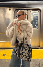 Side view of a sand faux fur jacket with a shaggy texture and voluminous sleeves