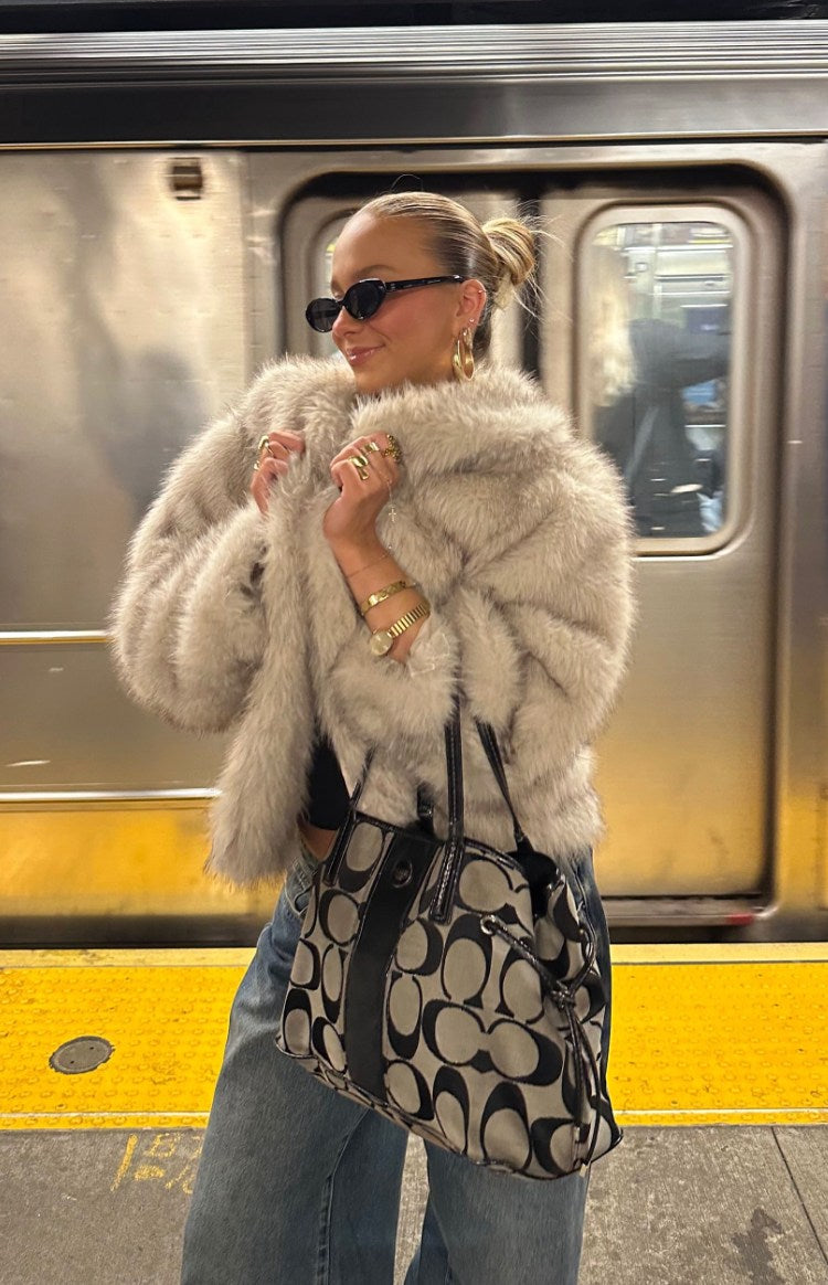 Side view of a sand faux fur jacket with a shaggy texture and voluminous sleeves
