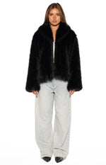 Front view of a black faux fur jacket with a wide collar, worn open to show the fluffy texture and cropped length
