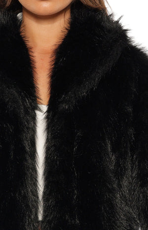 Detail shot showing the shaggy black faux fur texture and collar of the jacket