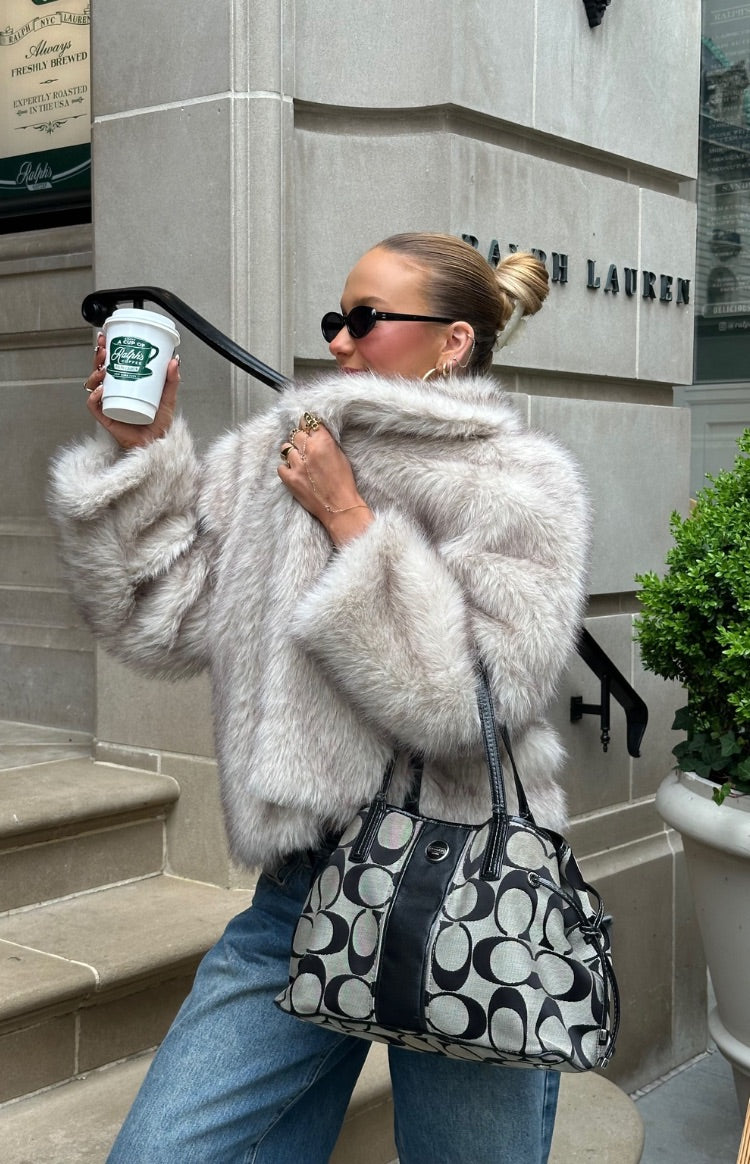 Side view of a sand faux fur jacket with a wide collar and plush texture