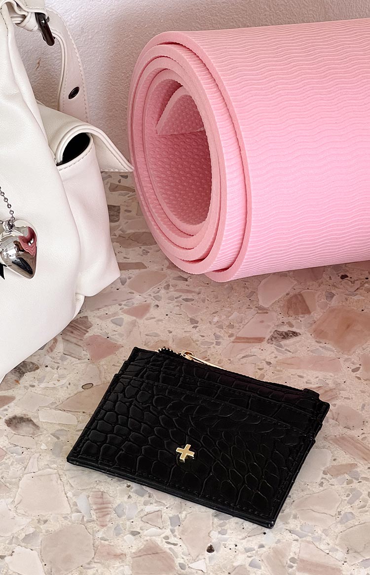Black croc embossed wallet with visible card slots, a gold zipper, and a gold cross emblem