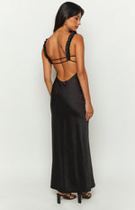 Back view of a black satin maxi dress with a low scoop back, thin horizontal straps, and ruffled shoulder straps