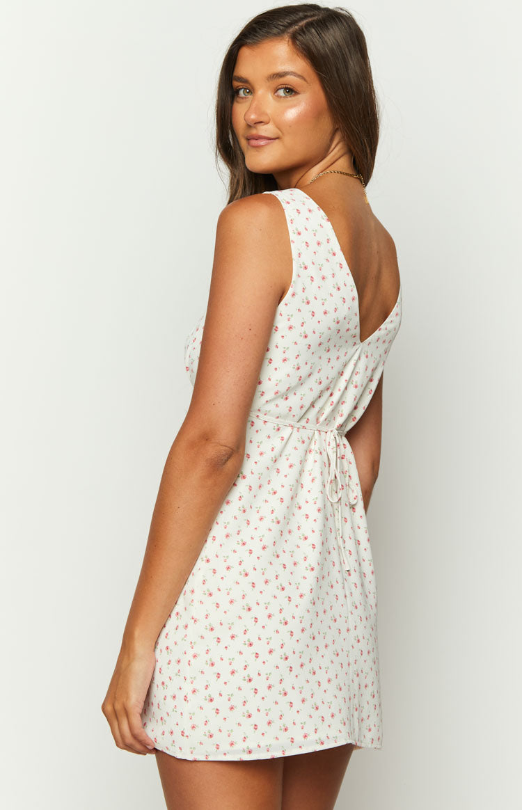 Rear view of the white mini dress with pink floral print, showing the deep V-back and tie-back waist detail