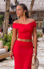 Front view of the red off-shoulder crop top with a crossover bust and ruched detailing on the sides