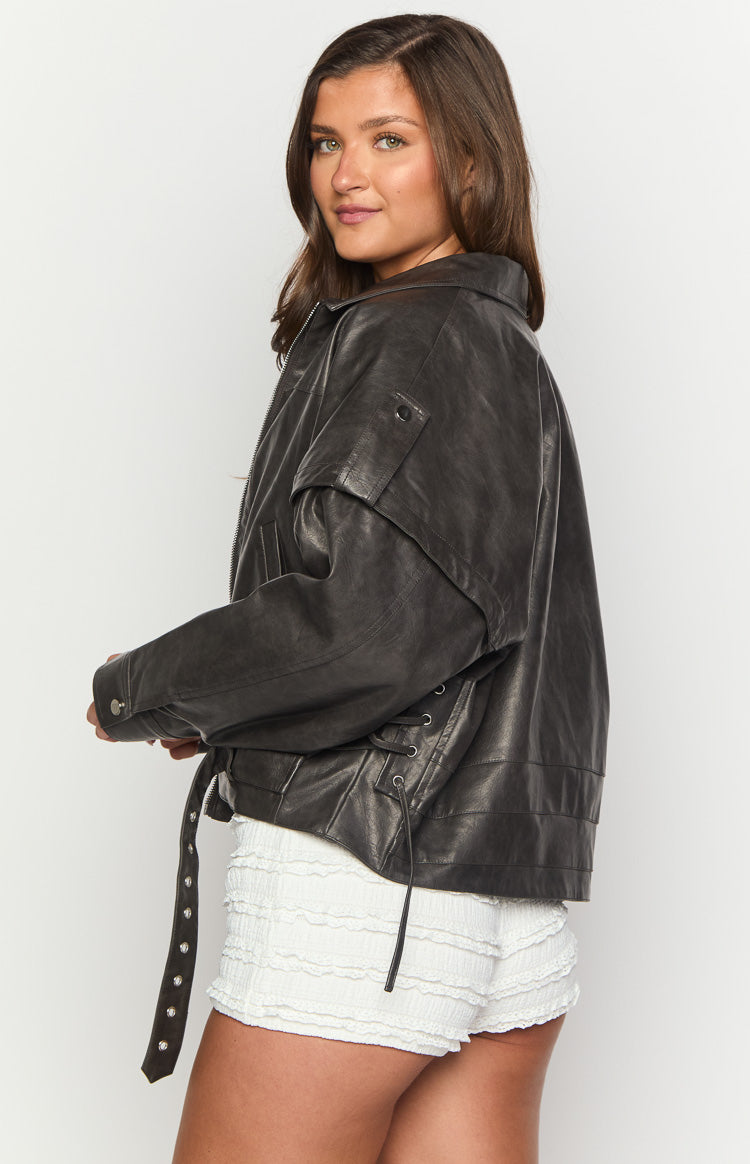 Side view of a washed black PU jacket showing the lace-up detail and adjustable buckle straps on the side